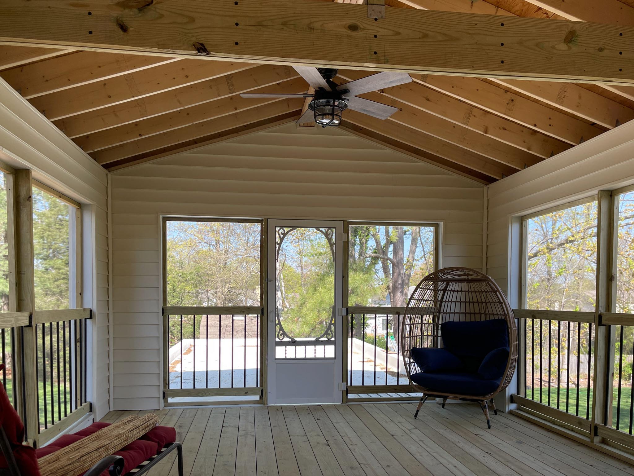 a porch with a chair and a fan
