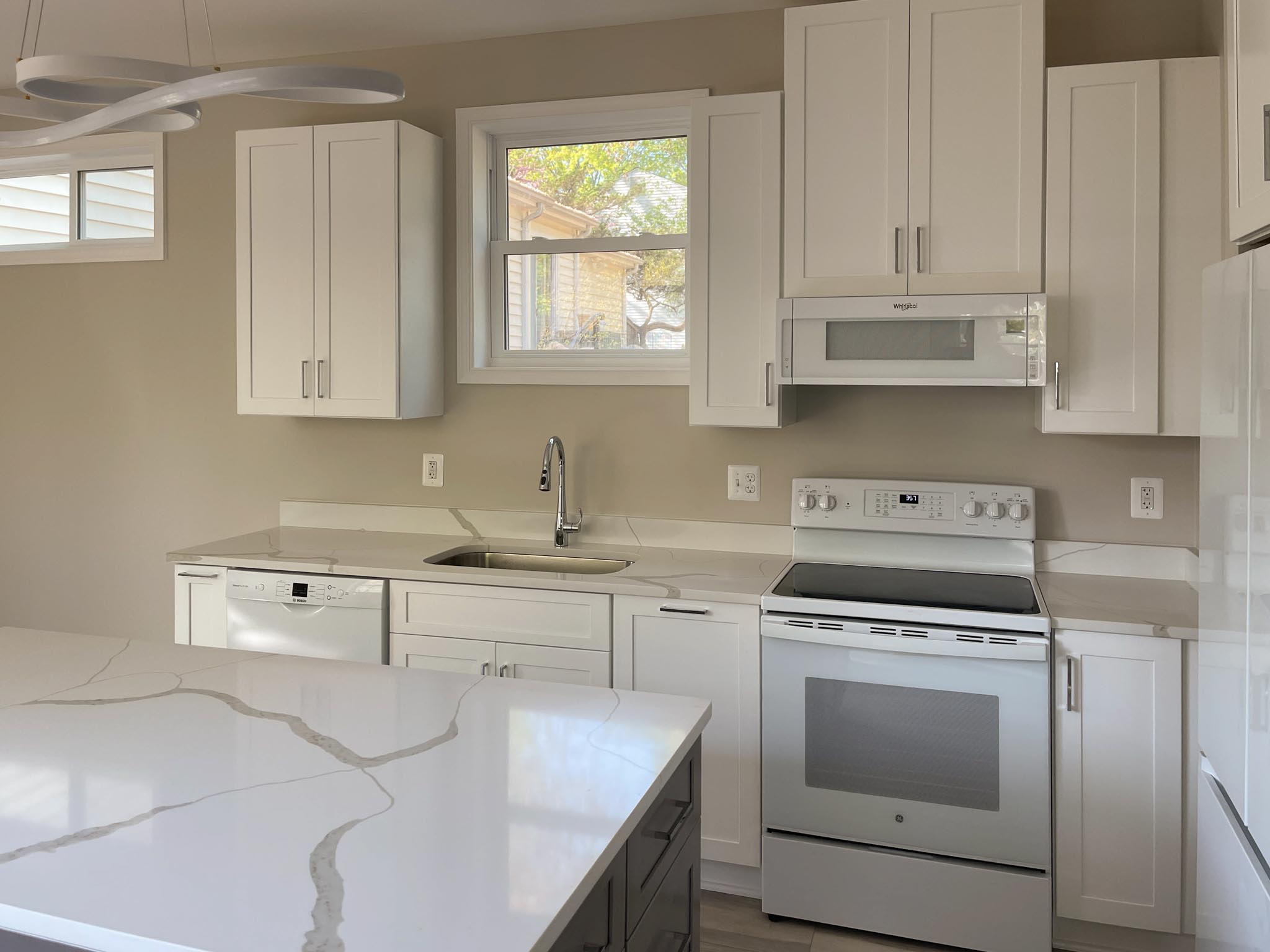 a kitchen with white cabinets and white counter tops
