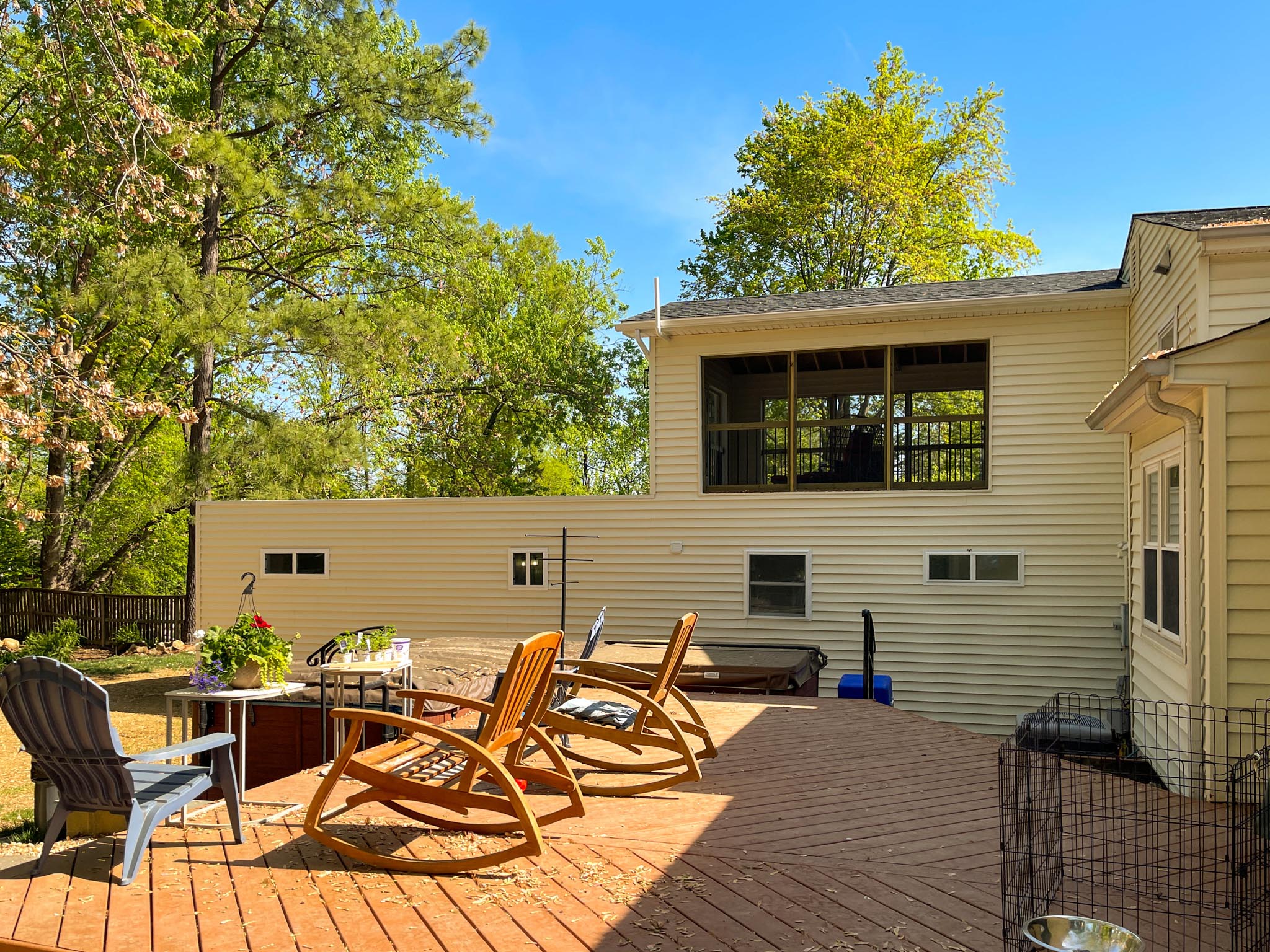 a deck with chairs and a dog kennel in the back